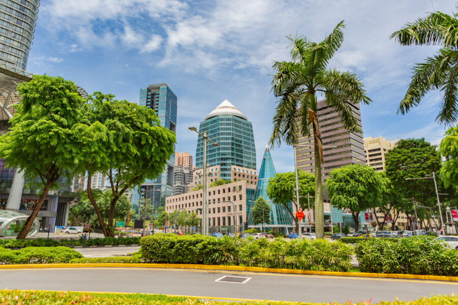 Orchard Road in Singapore featuring modern buildings, lush trees, and a vibrant skyline