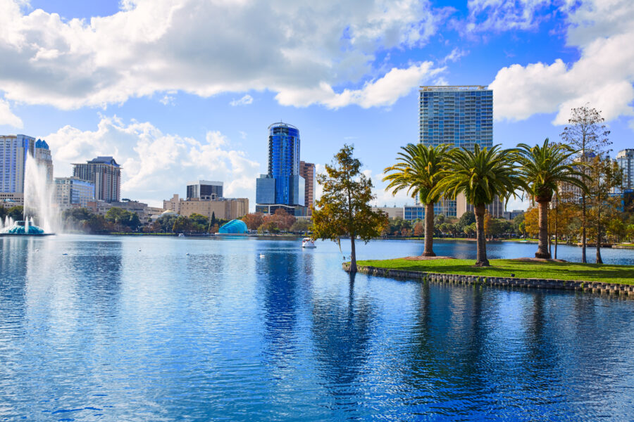 Orlando skyline viewed from Lake Eola, showcasing modern buildings against a clear blue sky