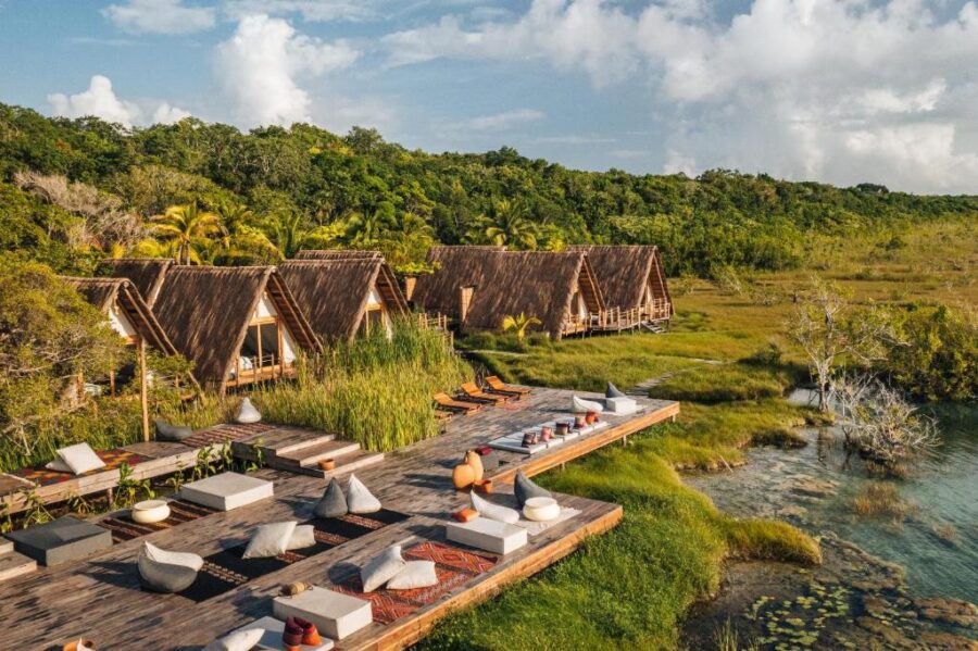 Aerial view of Habitas Bacalar resort featuring a pool, beach, and lush tropical surroundings, designed for adults only.