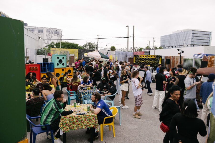 Urban social gathering with diverse crowd, colorful decor, and lively music atmosphere.