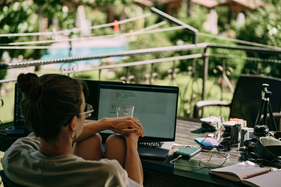Serene outdoor workspace with laptop, greenery, and camera gear for modern remote work.