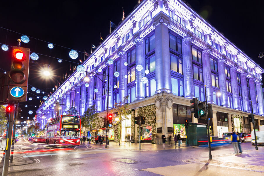 Festive Christmas illumination lights brighten Oxford Street shops in London, England, enhancing the holiday shopping experience