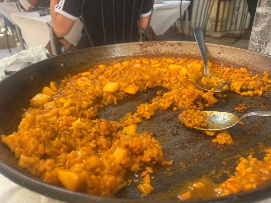 Vibrant arroz a banda with seafood in a communal dining setting.