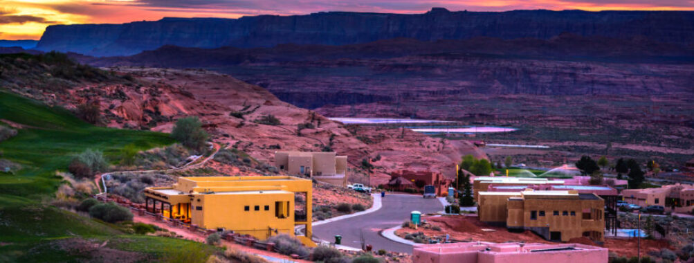 Expansive view of Page, Arizona at sunset, highlighting the dramatic sky and the unique geological features of the area.