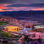 Expansive view of Page, Arizona at sunset, highlighting the dramatic sky and the unique geological features of the area.