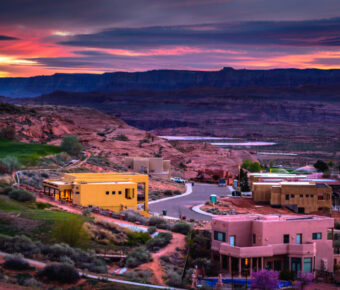 Expansive view of Page, Arizona at sunset, highlighting the dramatic sky and the unique geological features of the area.
