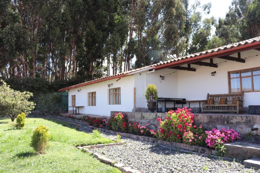 Palacio Manco Capac by Ananay Hotels, featuring a house surrounded by a vibrant garden and blooming flowers in Peru.