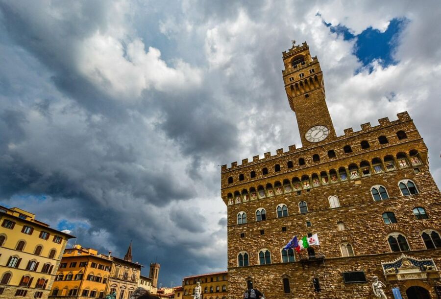 Palazzo Vecchio in Florence: Historic architecture, dramatic sky, vibrant piazza, rich heritage.