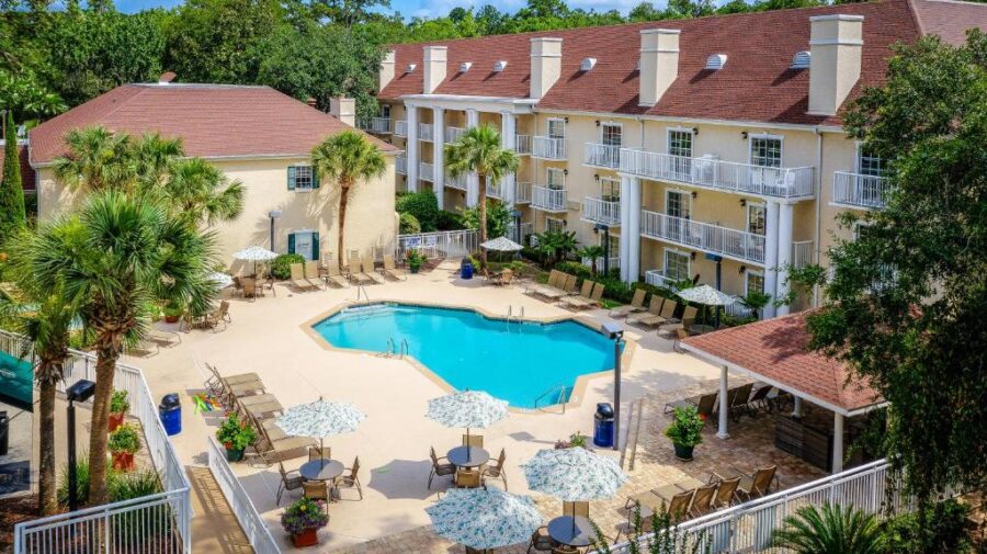 The inviting pool at the Palmera Inn and Suites in Hilton Head, designed for leisure with sun loungers and tropical plants.