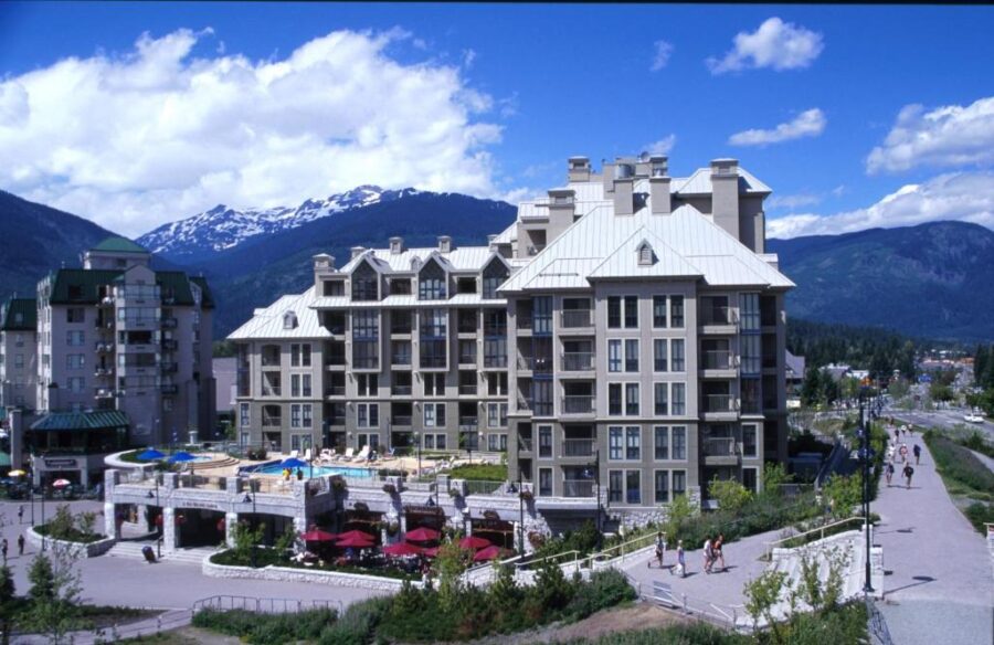 Pan Pacific Whistler Mountainside hotel with a large building set against a backdrop of majestic mountains.