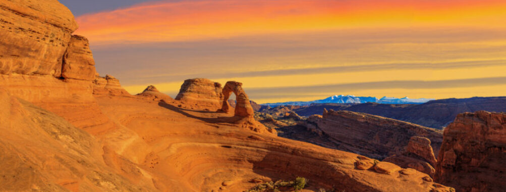 Panoramic landscape of Arches National Park featuring iconic red rock arches and desert scenery.