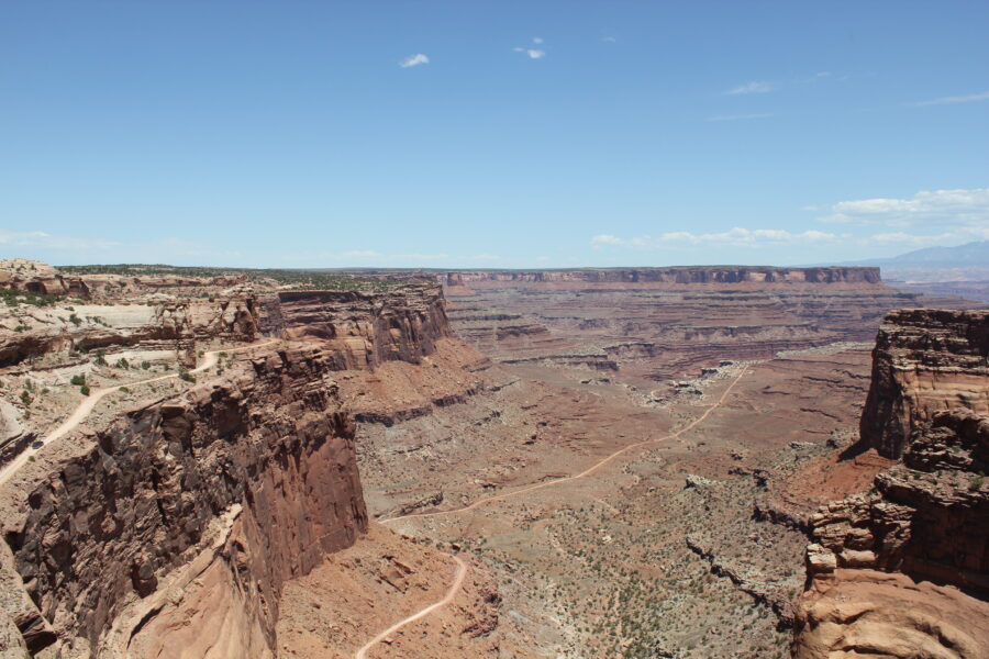 Person on a horse explores the dramatic canyon scenery of Canyonlands National Park, highlighting its natural beauty.