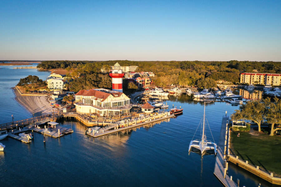 Aerial panorama of Harbour Town and its iconic lighthouse on Hilton Head Island, South Carolina, showcasing the coastal landscape.
