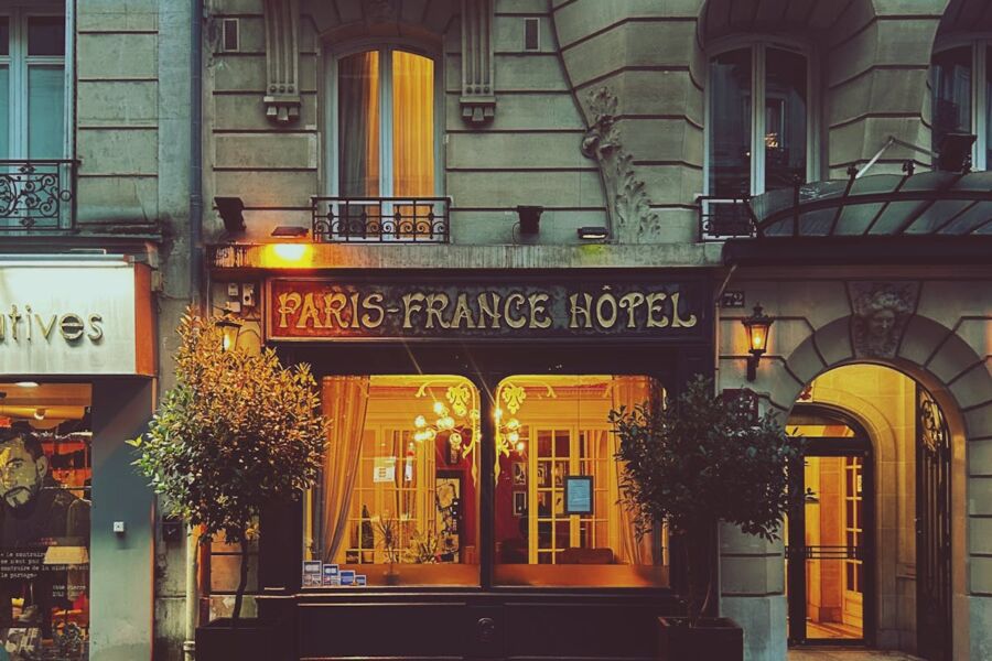 Paris-France Hotel at night: vintage elegance meets modern contrast with warm lighting.