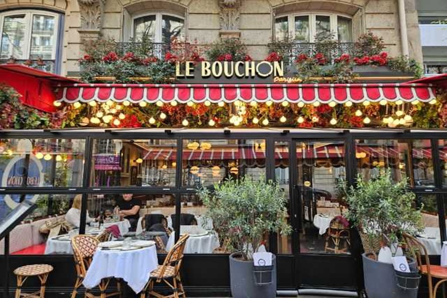 Charming Parisian bistro Le Bouchon with iconic awning and inviting outdoor seating.