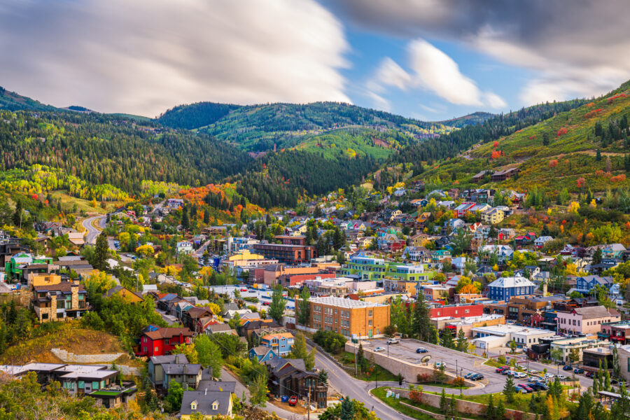 Park City, Utah skyline framed by lush green hills and trees, showcasing a vibrant city amidst natural beauty