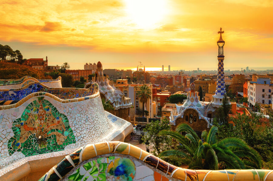 Panoramic sunset view of Barcelona from Park Guell, showcasing the city's vibrant architecture