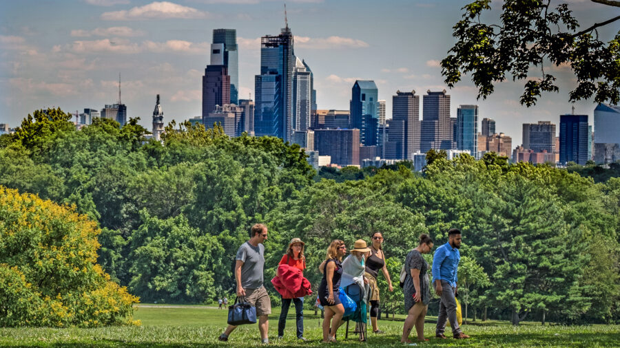 People enjoy Fairmount Park with Philadelphia skyline in the background.