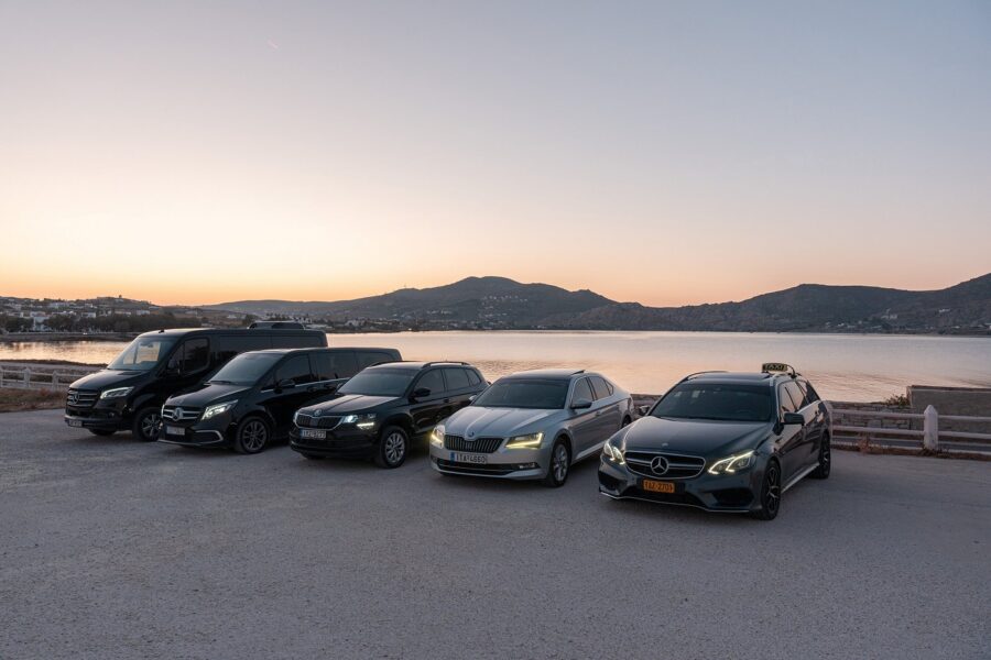 Coastal taxi and van fleet parked at sunset.