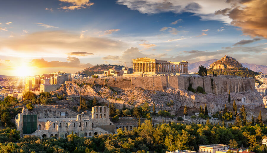 Sunset over the Acropolis in Athens, featuring the Parthenon temple against a colorful sky