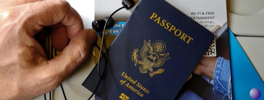 Travel preparation with US passport, earphones, and entertainment magazine on plane.