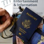 Travel preparation with US passport, earphones, and entertainment magazine on plane.