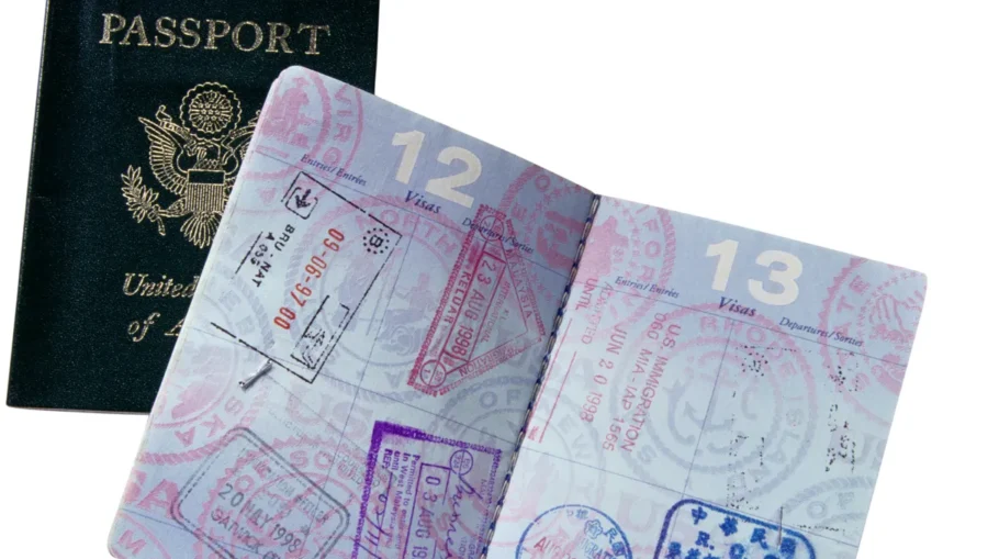 Close-up of a well-traveled U.S. passport with stamps, pages 12 and 13 visible.