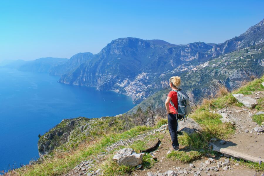 Hiker gazing at breathtaking coastal scenery on the famous Path of the Gods trail in Amalfi, Italy.
