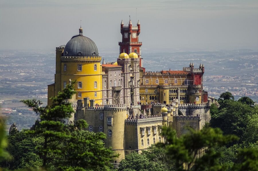 Pena Palace in Sintra, Portugal: vibrant colors, Romantic architecture amidst lush greenery.