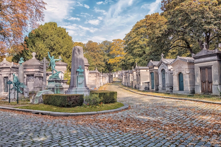 Peaceful scene at Père-Lachaise Cemetery, showcasing intricate gravestones surrounded by trees and pathways in Paris