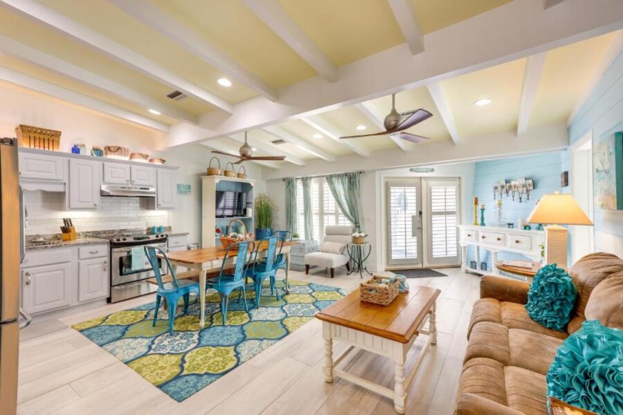  Bright living room and kitchen space with blue accents, showcasing a pet-friendly design in a Jekyll Island abode.