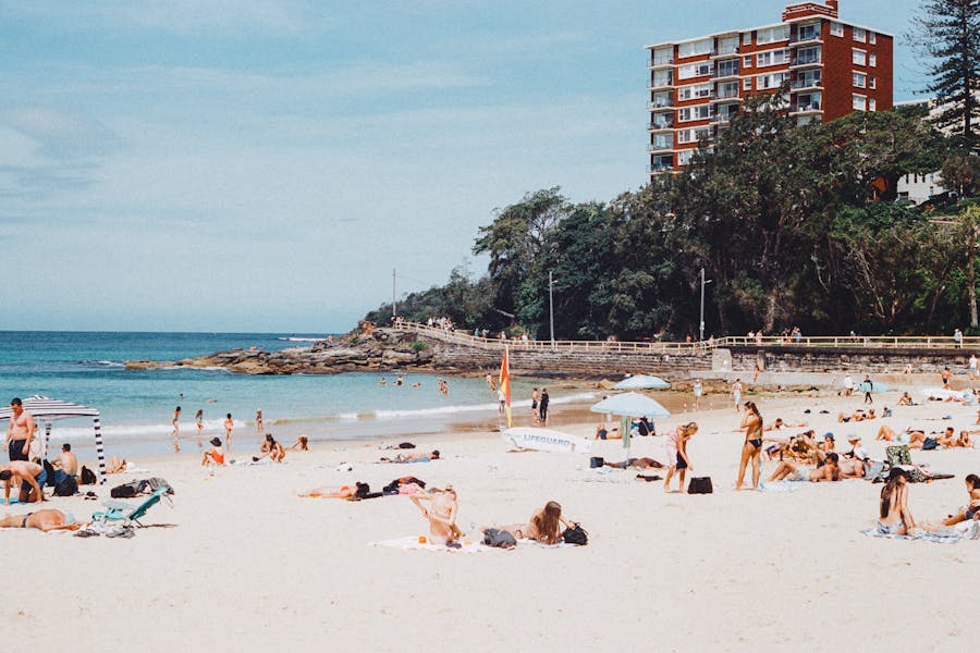People at Beach by Sea in front of High Rise Buil