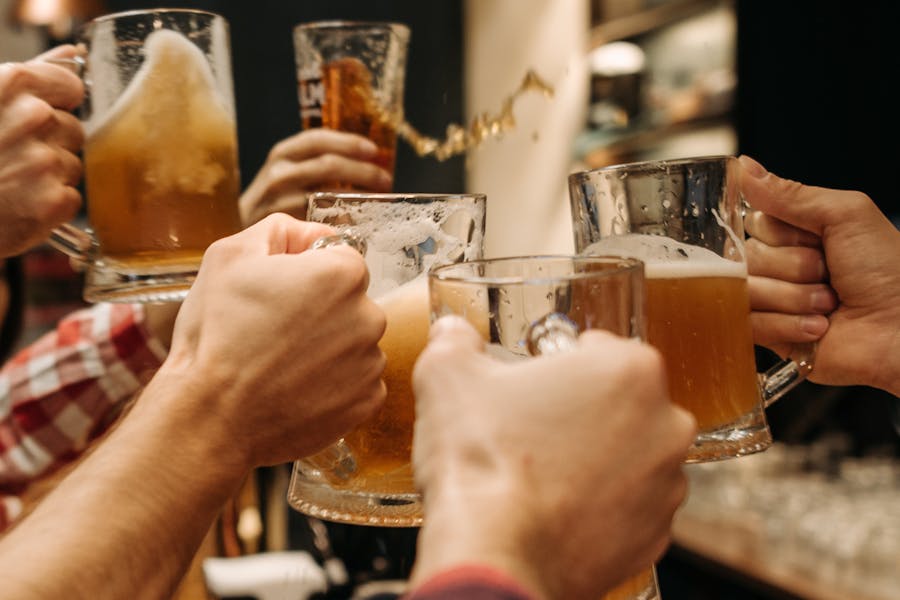 Friends Clicking Glasses of Prague Beer in Bar