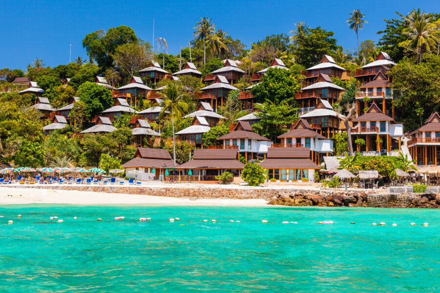 Phi Phi The Beach Resort features a beautiful beach, palm trees, and inviting turquoise waters under a clear sky