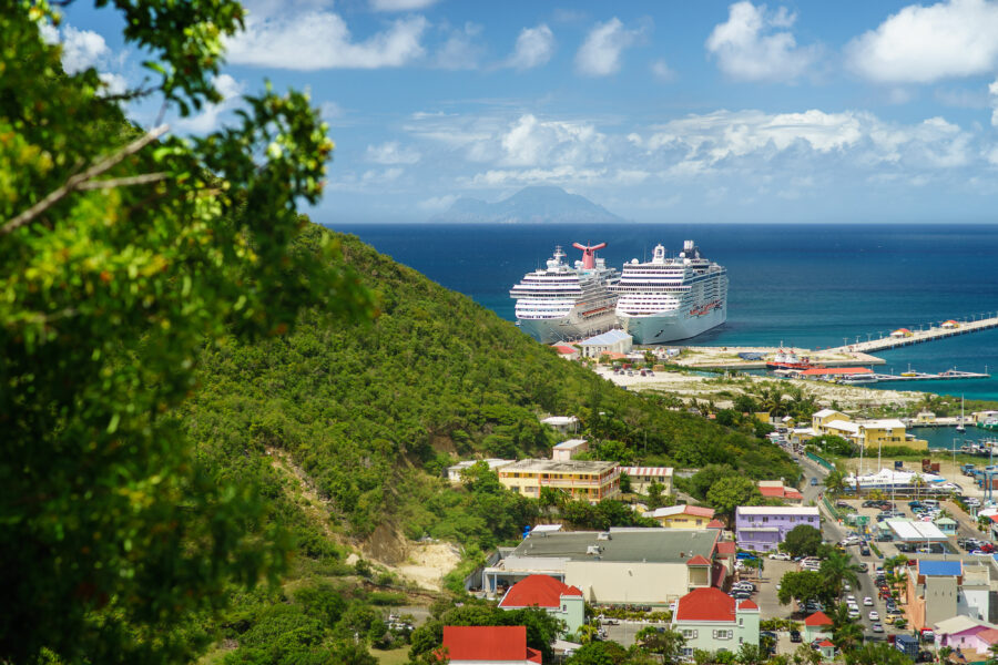 Aerial view of Philipsburg port in Sint Maarten, showcasing multiple cruise ships docked along the waterfront.