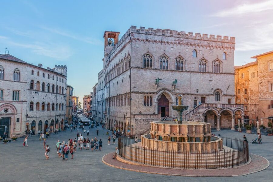 Historic palazzo and tiered fountain in sunlit Italian piazza at the University for Foreigners.