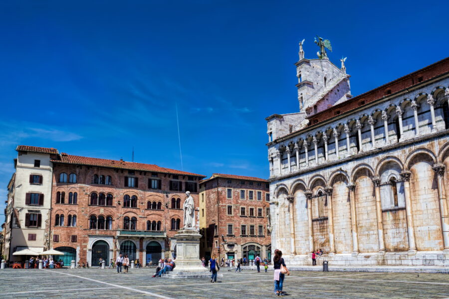 Piazza San Michele in Lucca, Italy, featuring a historic church and lively atmosphere with people