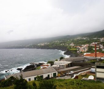 Picturesque small town on Pico Island, Portugal, featuring a lighthouse perched on a hill overlooking the landscape.