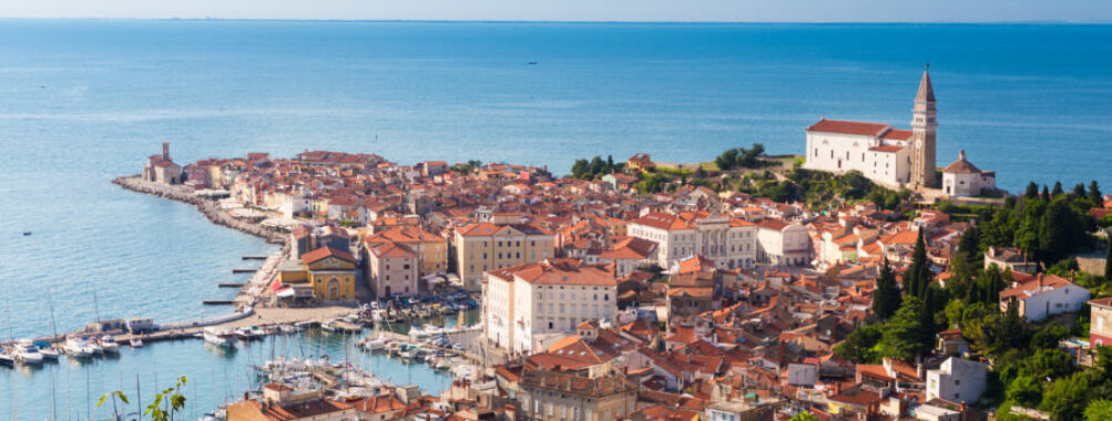 Scenic view of Piran's charming old town in Slovenia, featuring historic buildings and a coastal backdrop.