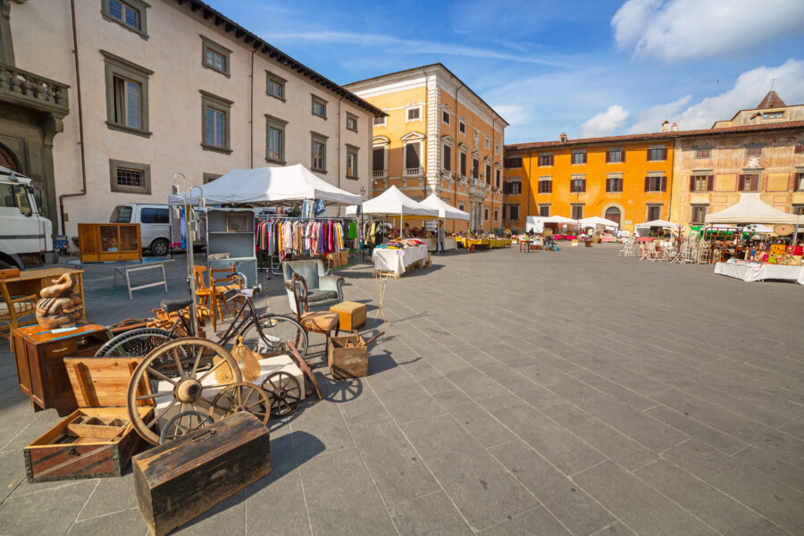 Traditional architecture lines the streets of Pisa, Italy, bustling with market activity and vibrant local culture