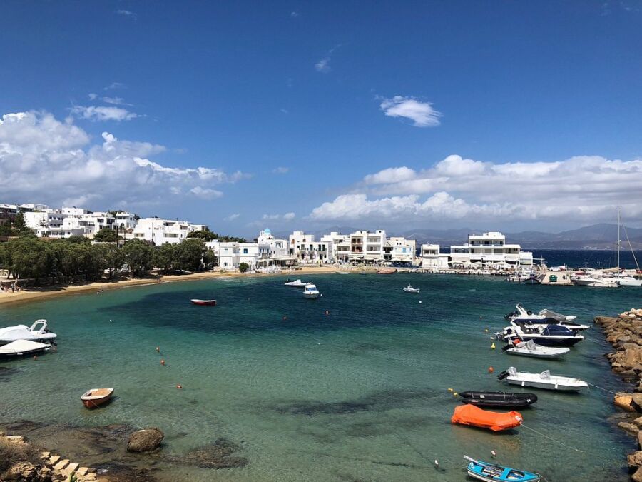 Panoramic view of the Bay of Paros from a hilltop in Piso Livadi, Greece, showcasing blue waters and surrounding landscape.