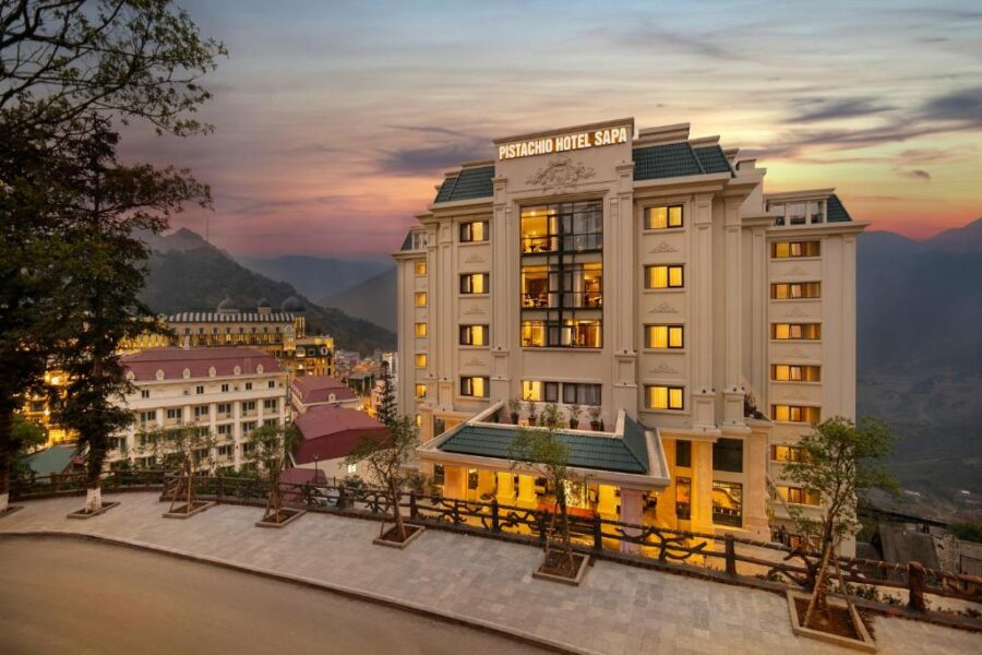 Pistachio Hotel Sapa luxury mountain resort at sunset with illuminated facade and panoramic views.