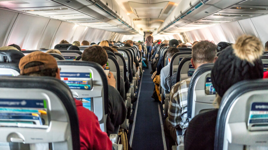 Passengers seated inside a commercial airplane, traveling together across the globe to various destinations.