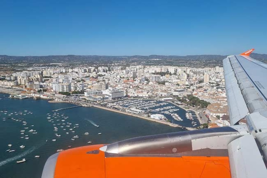 Aerial view from airplane wing over Faro coast and marina, Portugal.