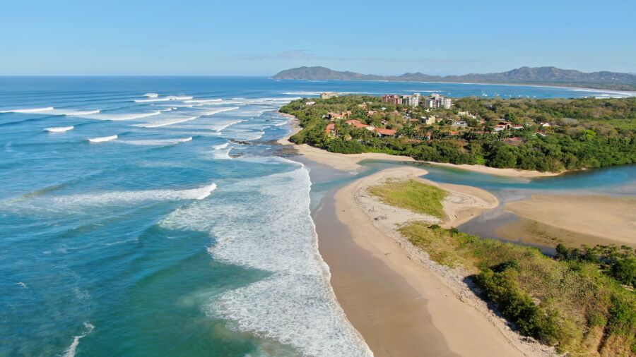 Panoramic view of Playa Langosta in Costa Rica, showcasing the beach, ocean, and surrounding lush greenery