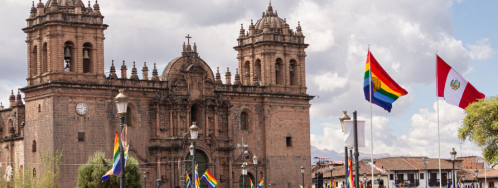 Plaza de Armas in Cusco, Peru, featuring colonial architecture, vibrant gardens, and a central fountain surrounded by visitors.