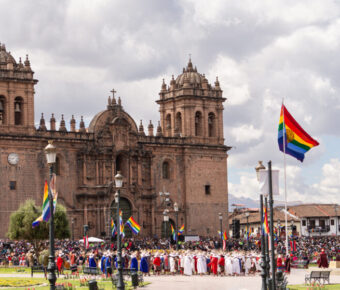 Plaza de Armas in Cusco, Peru, featuring colonial architecture, vibrant gardens, and a central fountain surrounded by visitors.