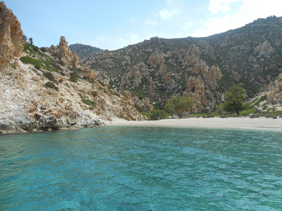 Tranquil waters of Polyaigos Island Beach, framed by soft sand and gentle waves, inviting relaxation and exploration.
