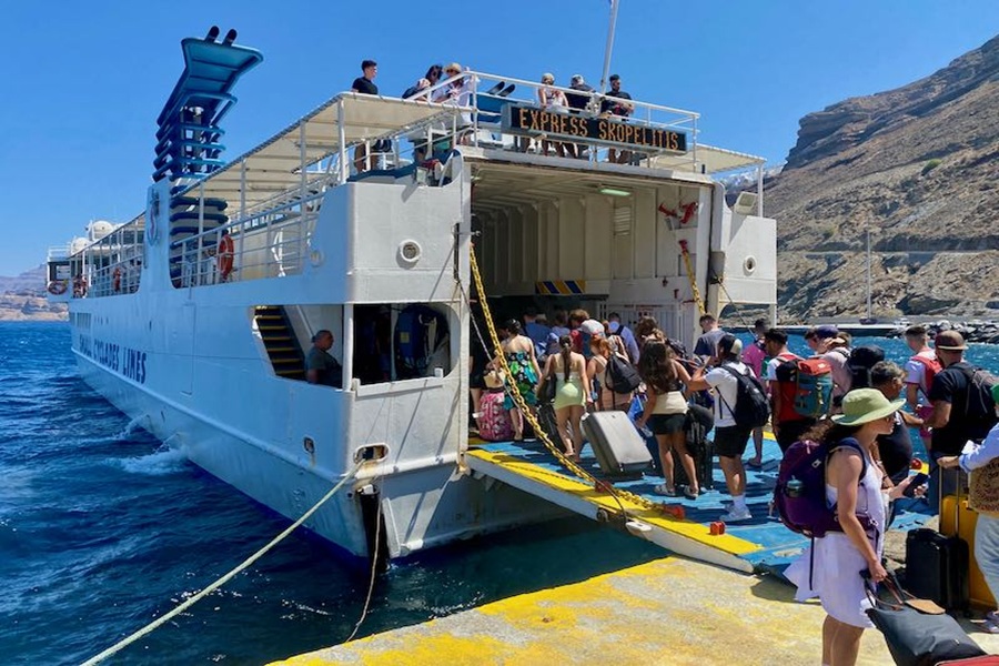 Ferry Express Skopelitis boarding passengers in scenic harbor, bound for adventure under sunny skies.
