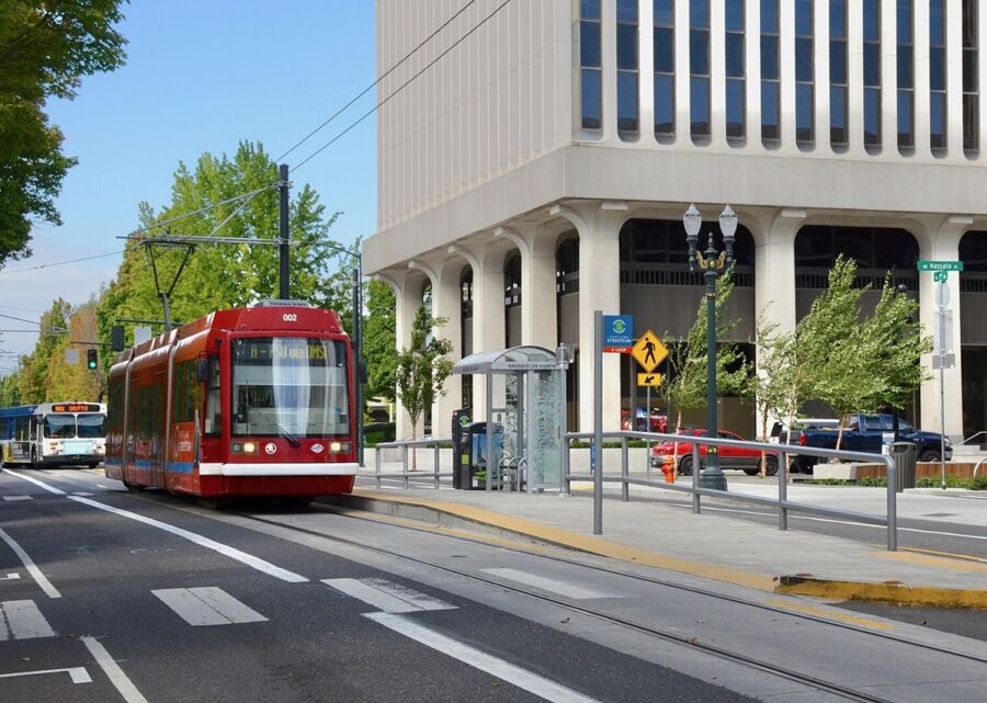 Red Portland Streetcar 002 at NE 7th Ave, highlighting modern urban transit.